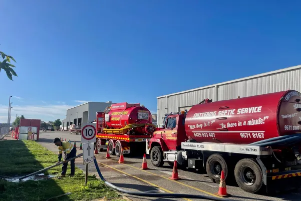 Chittering Septic Service fleet of red vacuum tanker trucks lined up outside a depot