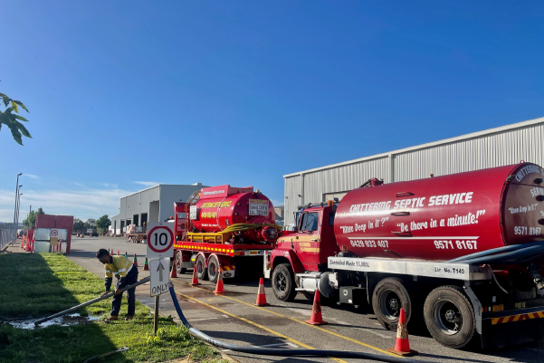 Two Chittering Septic Service tankers parked behind safety cones on a job