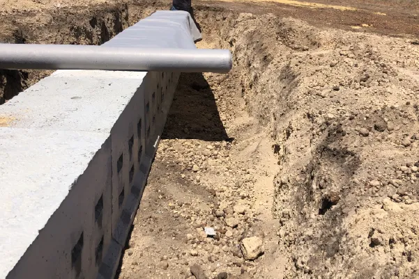 Concrete leach drain exposed in a trench during rejuvenation works