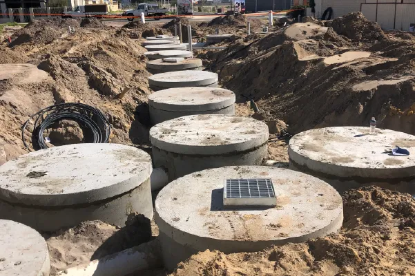 Concrete soak wells lined up in a trench ready for installation